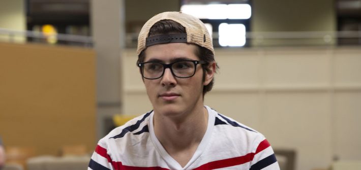 Tom Julian wearing a background hat sitting in the Student Center