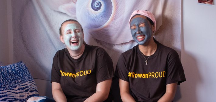 Two students in a dorm room doing face masks together