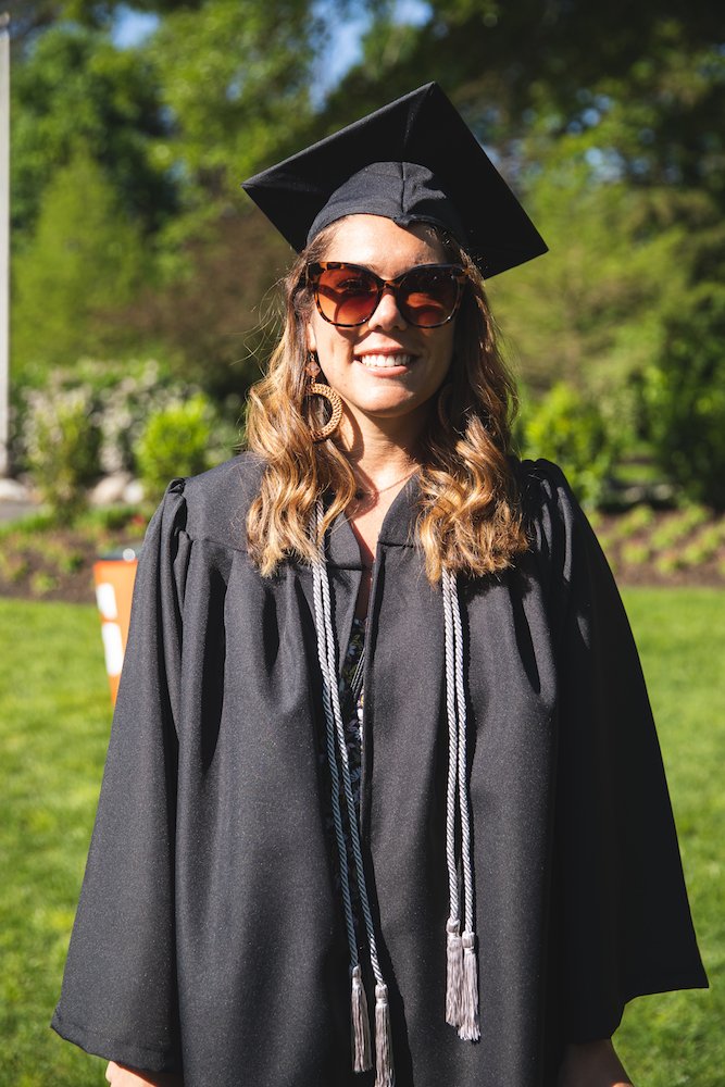 Allyson in her cap and gown standing on the Bunce Green.