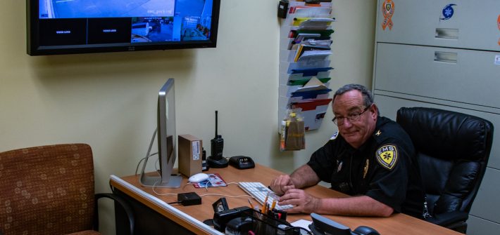 Rowan EMS employee sitting at his desk working diligently on a Mac computer