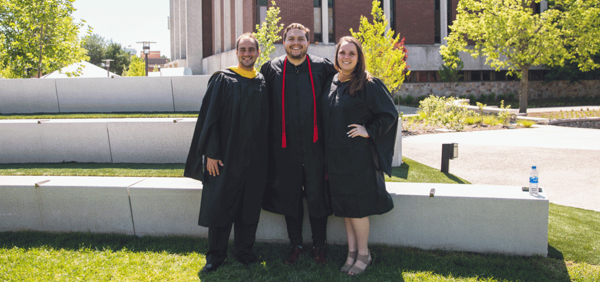 Three Rowan graduates standing together outside Robinson Hall
