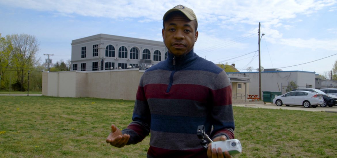 Rashaun Brown stands outside in the vacant lot.