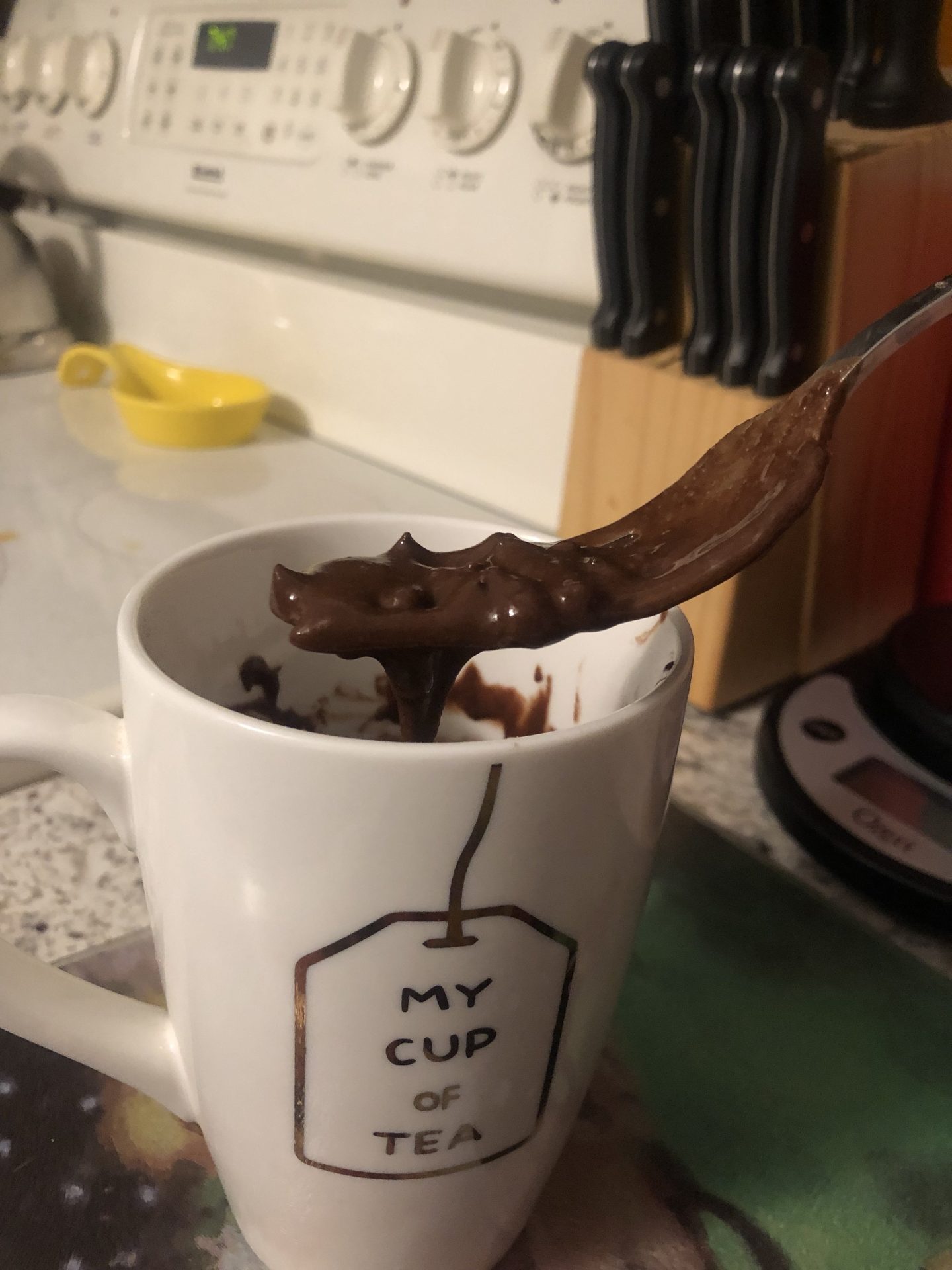 a fork with nutella on it above a mug