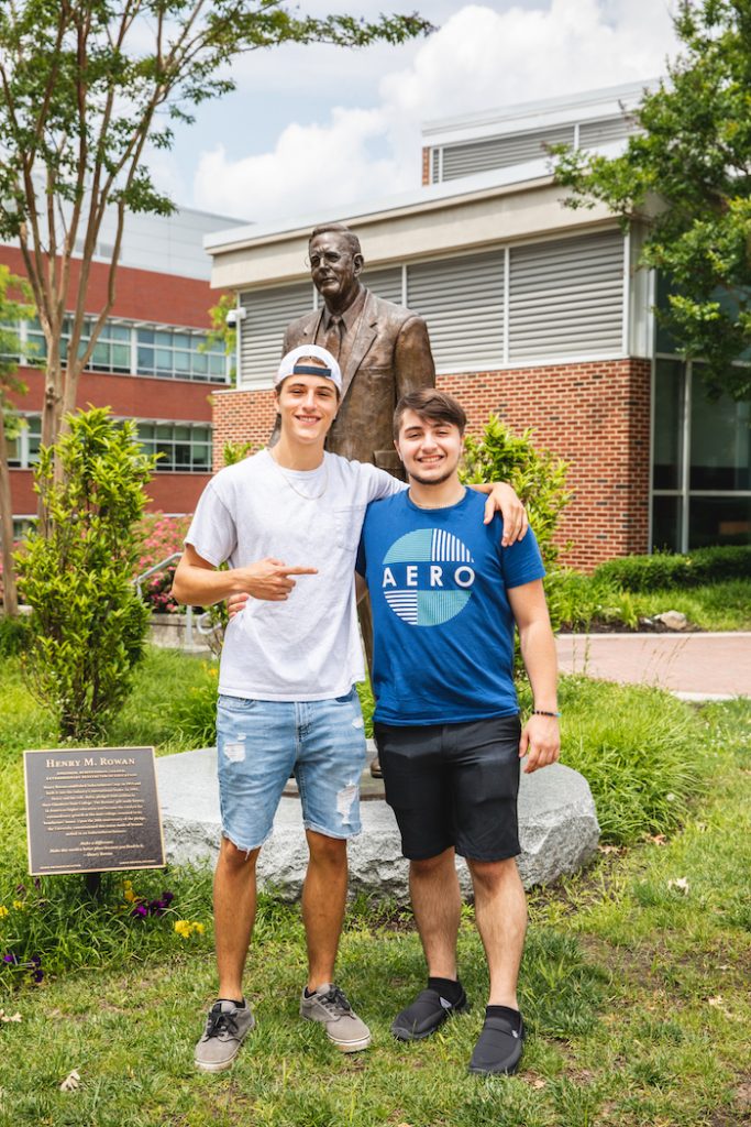 Dillon Weigand puts his arm around twin Chase Weigand in front of the Henry Rowan statue at Rowan University