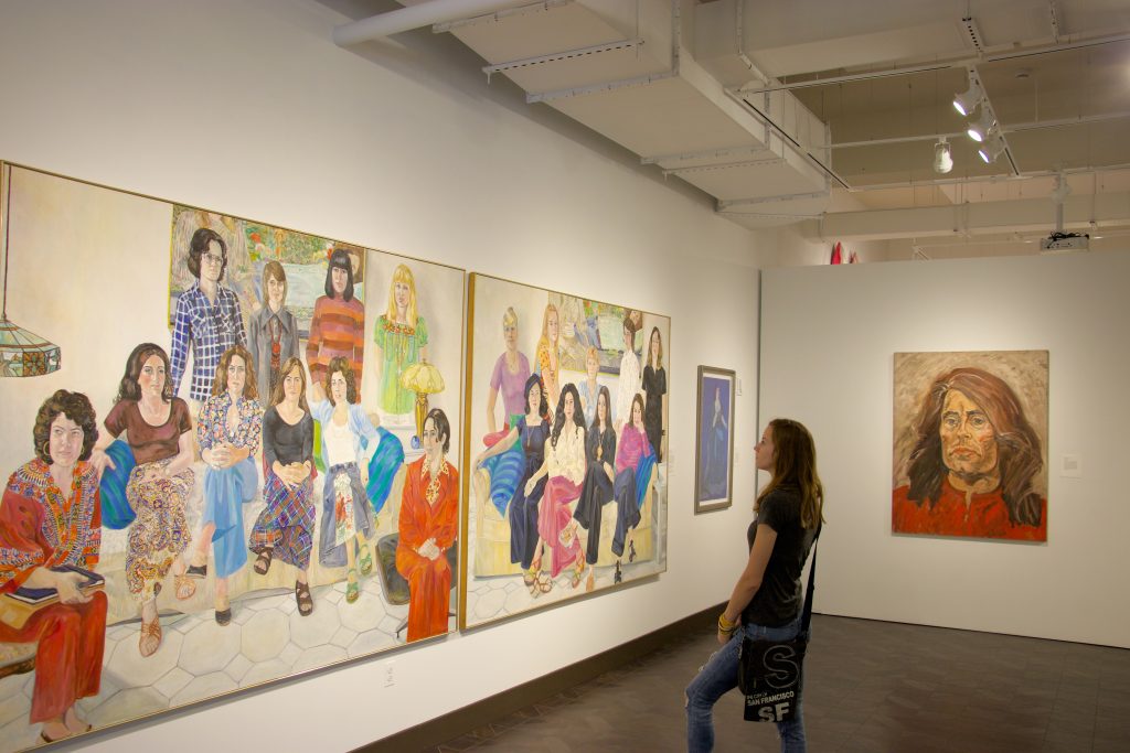 Girl looking at painting on the wall in the art gallery