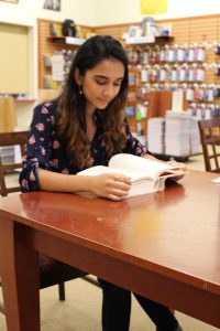 Molecular and cellular biology major Amaal Khan sitting and reading a book at Rowan Barnes and Noble