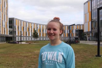 Elizabeth Hudak stands in front of Holly Pointe Commons at Rowan University with the building behind her
