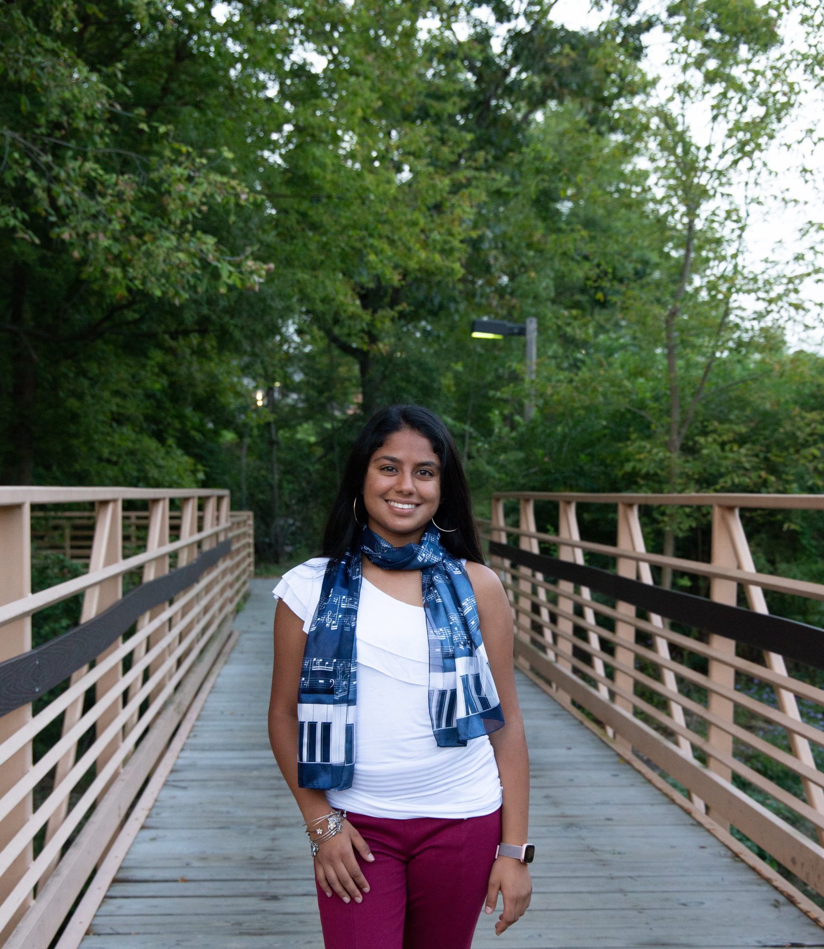 Shreya Shah posing on the bridge behind Rowan University's Business Hall.