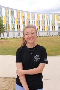Bioinformatics major Kelly Kirk in front of Holly Pointe Commons