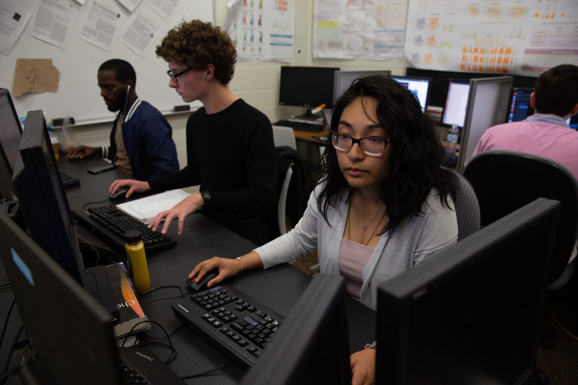 Rowan Bioinformatics major Anne Marie Fernandez sitting a computer lab with students.