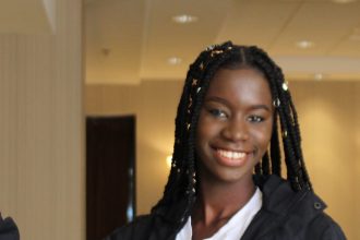 Mary Gomez, an international student and Community Health major, stands inside the Chamberlain Student Center