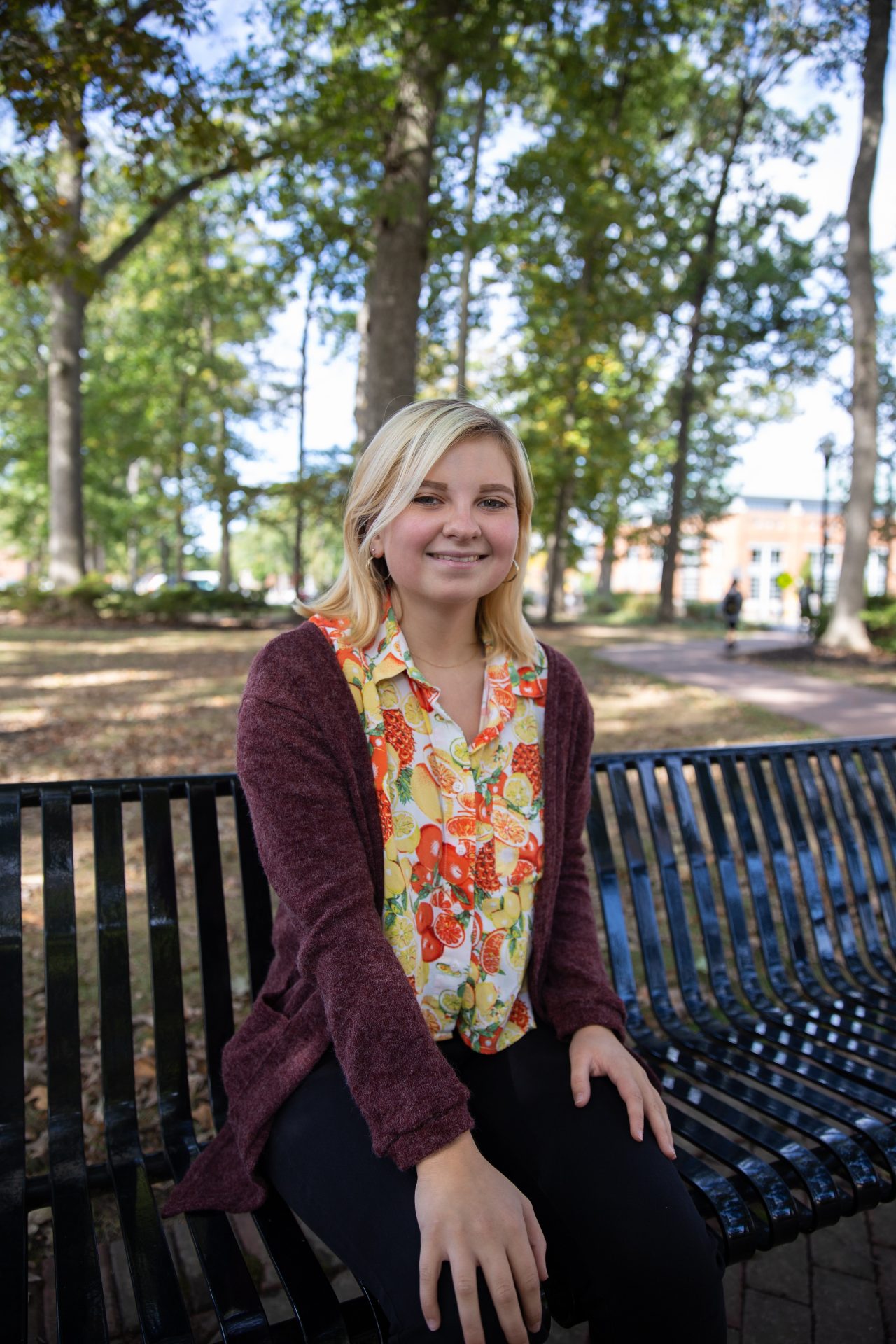 Grace Van Cleef posing on a bench on Rowan University's campus.