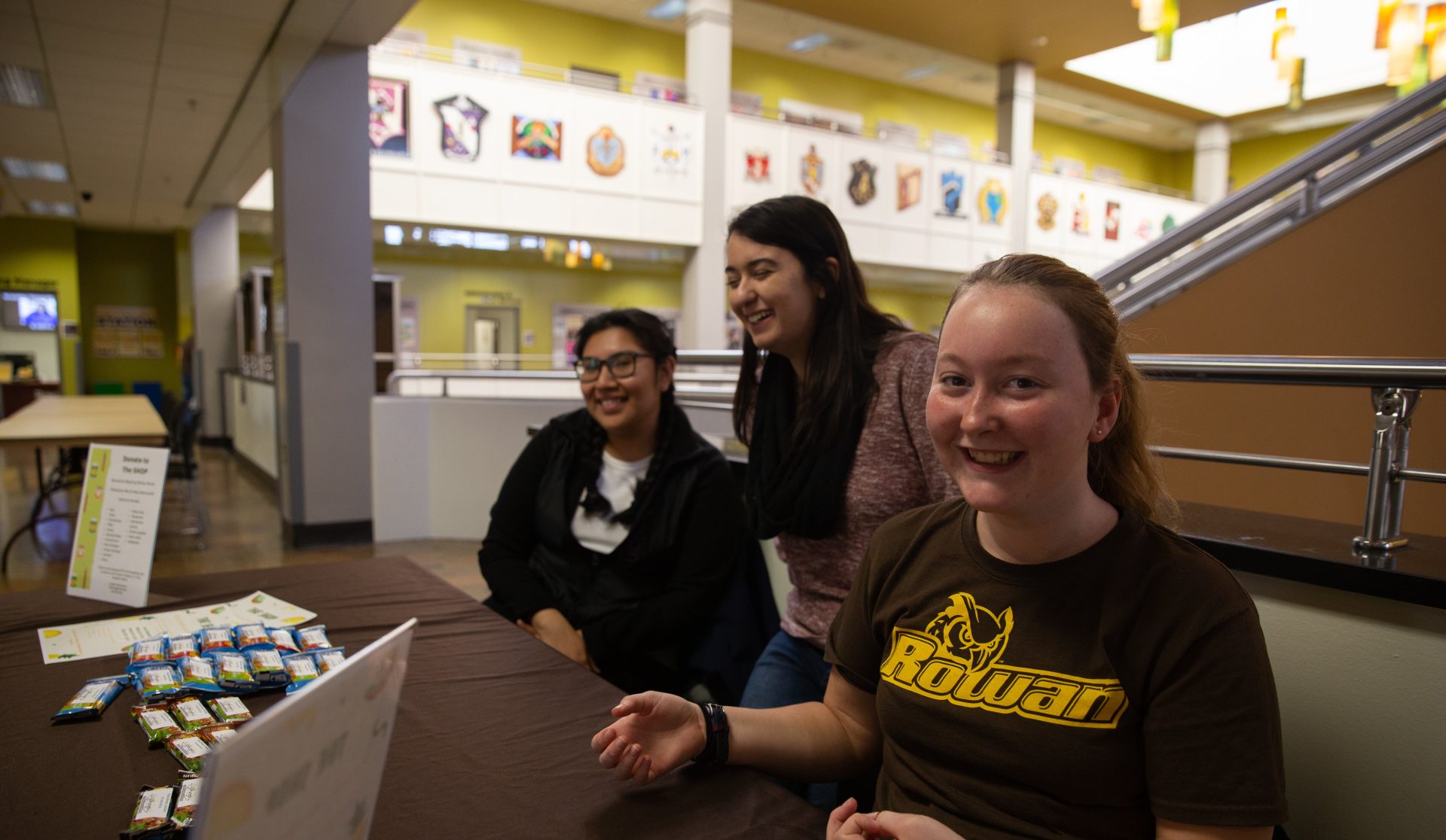 Rachel Rumbsy (right) hands out granola bars at Rowan University's Student Center for The SHOP.