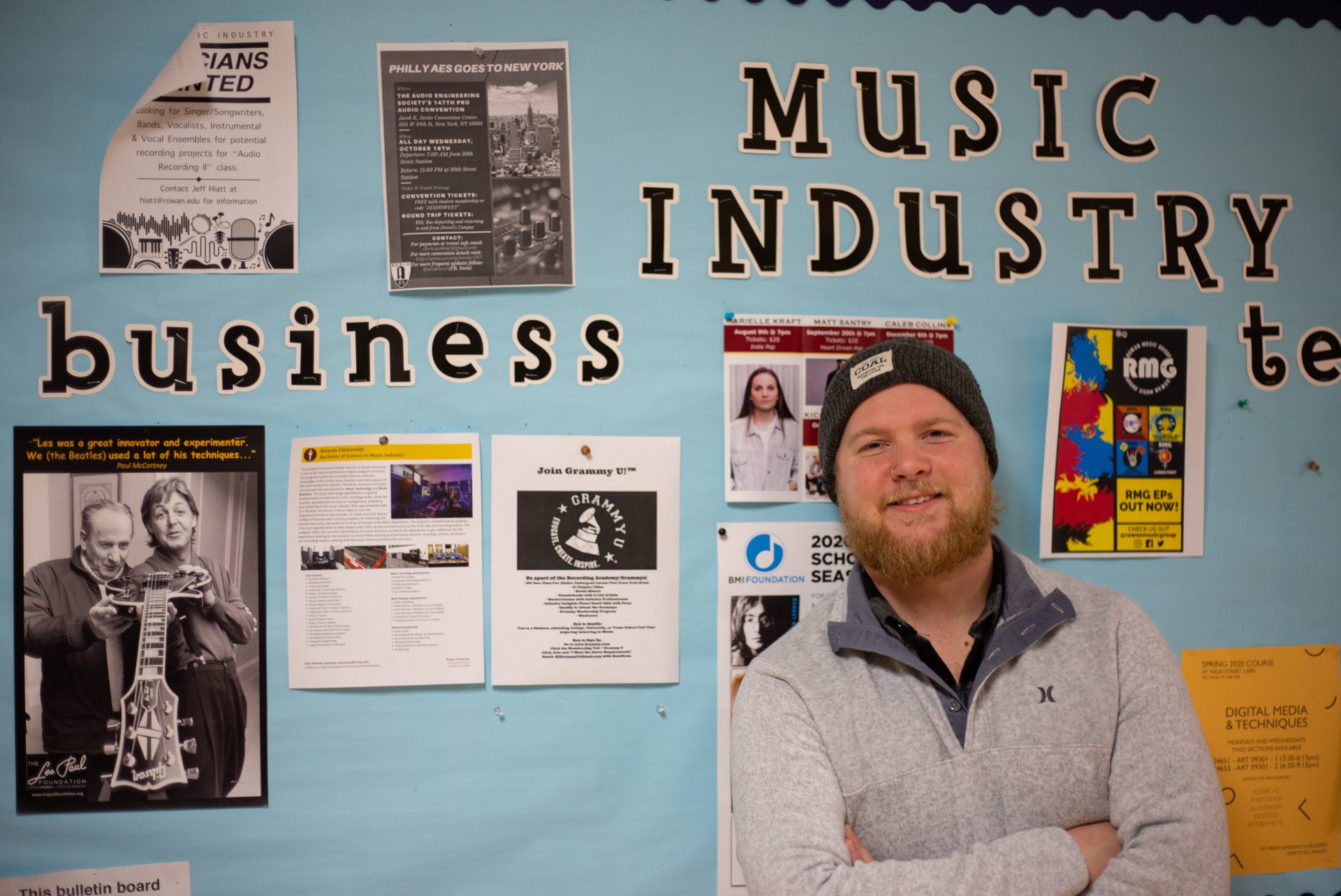 Music Industry major Jeff McConnell stands in front of a hallway display
