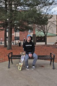 Freshman Music Industry major Devin Saienni sits on a bench on campus