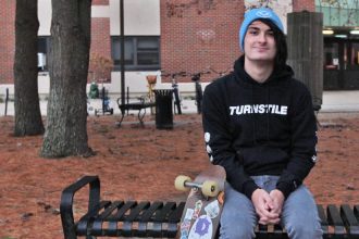 Freshman Music Industry major Devin Saienni sits on a bench on campus