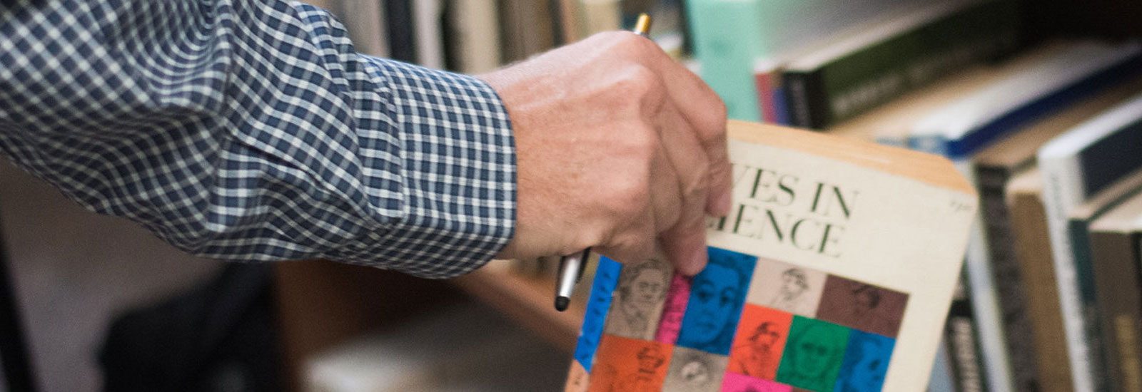 Matthew Lund taking a book from his collection