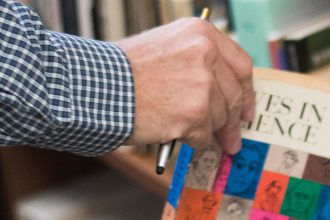 Matthew Lund taking a book from his collection