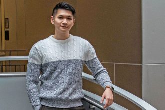 Thai Nghiem stands on the steps inside the Engineering Hall lobby