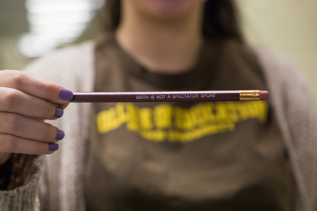 A close up photo of a pencil that reads "Math is not a spectator sport."