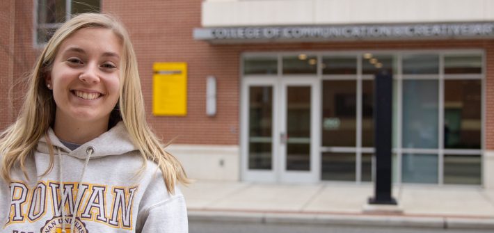 Communication Studies major Ashley Davis stands in front of Victoria Hall