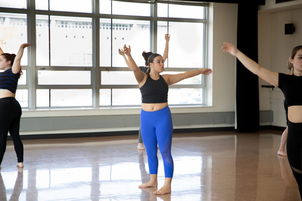 Sabrina is dancing in her modern dance class with classmates.