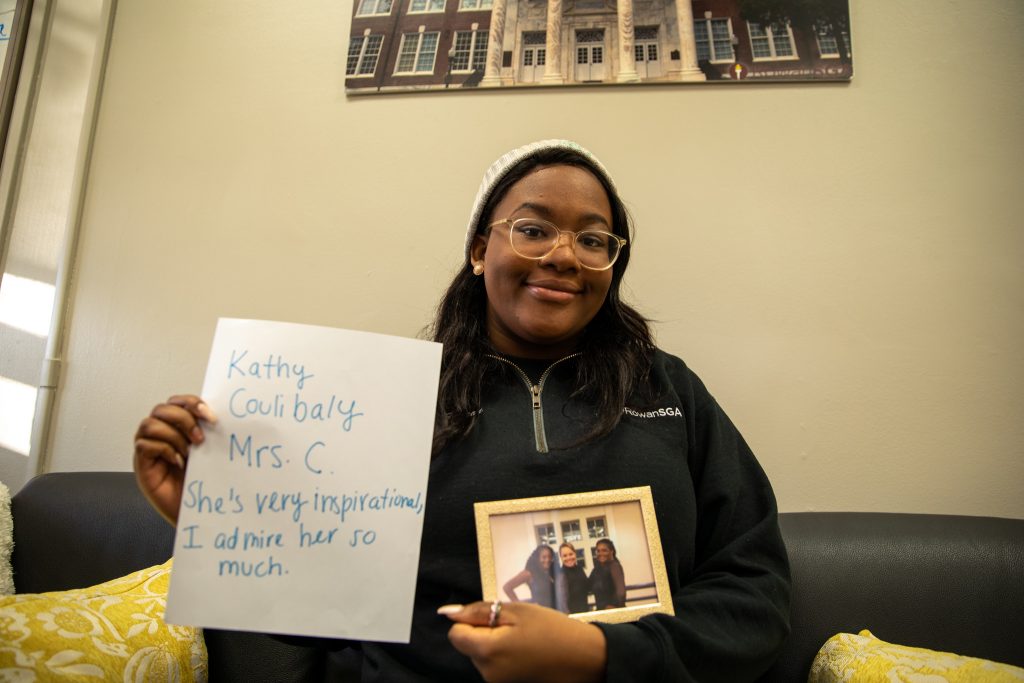 Arielle Holding her answer as well as holding a photo of her sister and a woman who inspires her named Kathy Coulibaly.