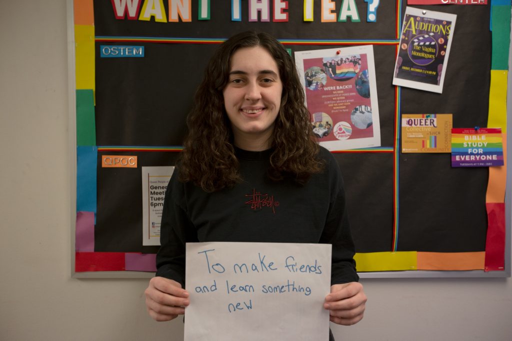 Abby holding up a sign that says "to make friends and learn something new."