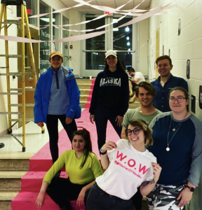 Jessica wears a Women of Westby t-shirt and stands with her peers in Westby Hall, as they prepare an installation.