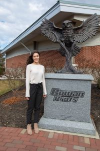 Kayla stands in front of the Prof statue by the Rowan University team house.