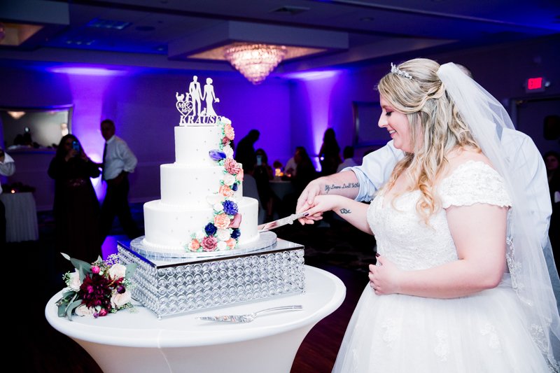 Enchanted Celebrations photo of a bride cutting wedding cake.