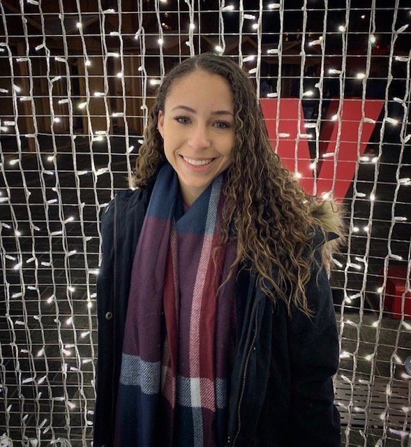 Vanessa Finnan smiles in front of a wall of string lights.