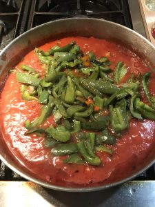 Add the peppers to the crushed tomatoes. 