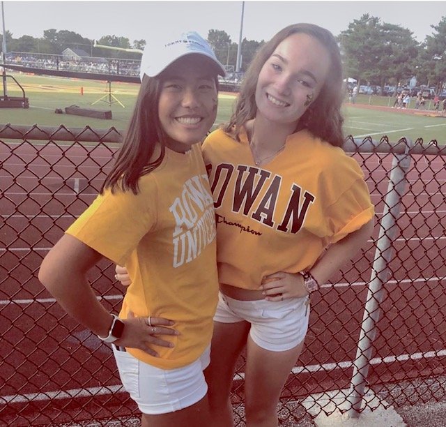 Abby posing with her friend at a football game.