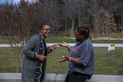 Faculty and student laugh together.