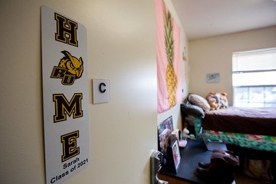 A Rowan dorm room, focused on the "Home" wall hanging with the O as a Rowan owl.