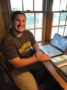 Chemistry major Jacob Emig sits at home in front of his open laptop.