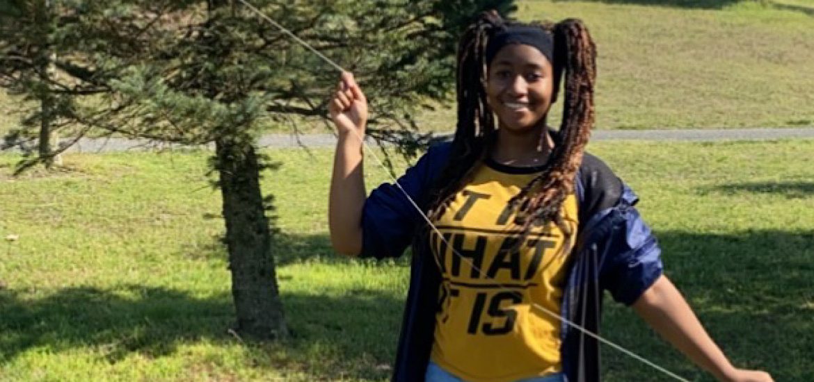 Photo of Maiyah outside in a yellow shirt and blue jacket