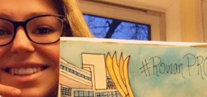 Selfie of Emma holding a drawing of Rowan.