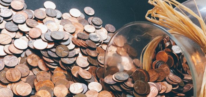 Stock image of pennies spilling out of a jar.