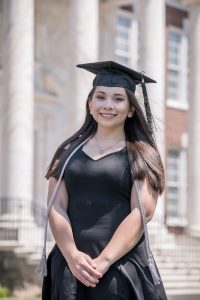 Computer science major Monica posing in graduation attire.