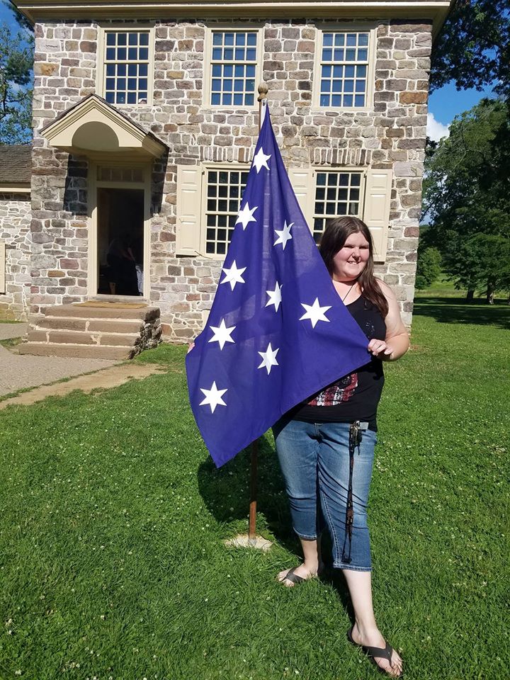 Sylvia stands with a flag.