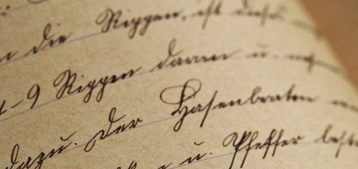 Stock image of black ink cursive on tepia colored paper.