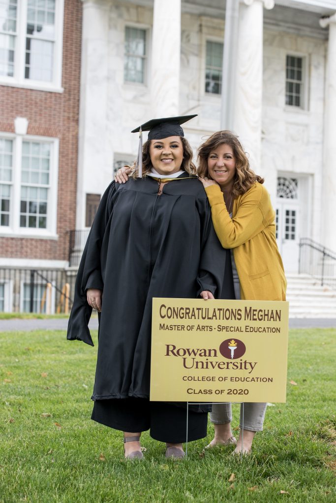 Megan Pfizenmayer stands with her mom and a graduation sign outside of Bunce Hall