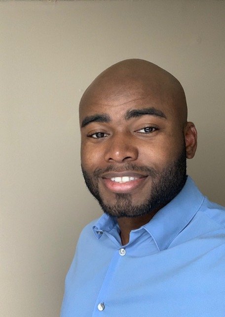 Headshot of Kemet wearing a blue shirt against a neutral background