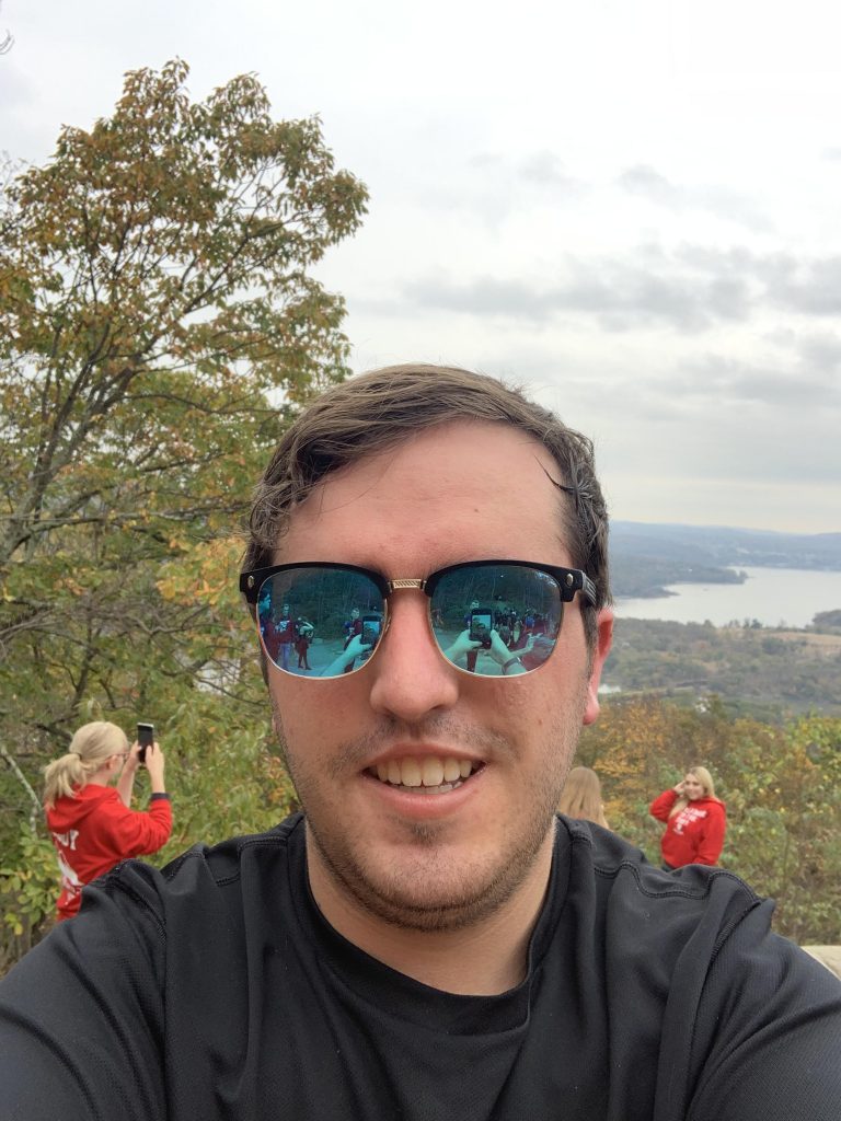 Outdoor selfie of Connor wearing reflective sunglasses
