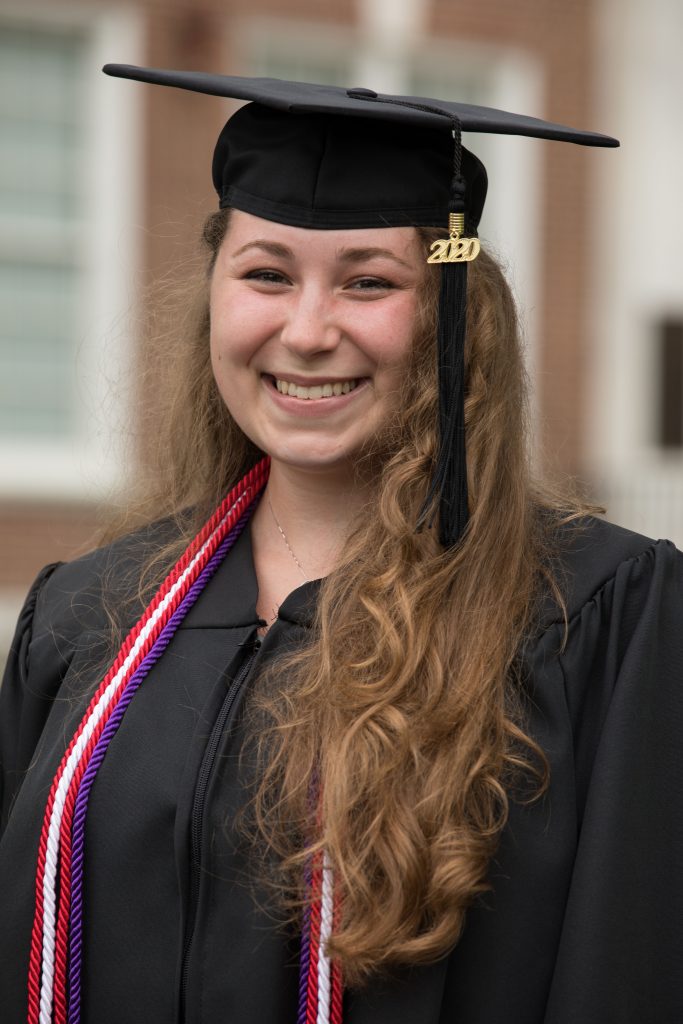 Kira wears her cap and gown in front of Bunce Hall