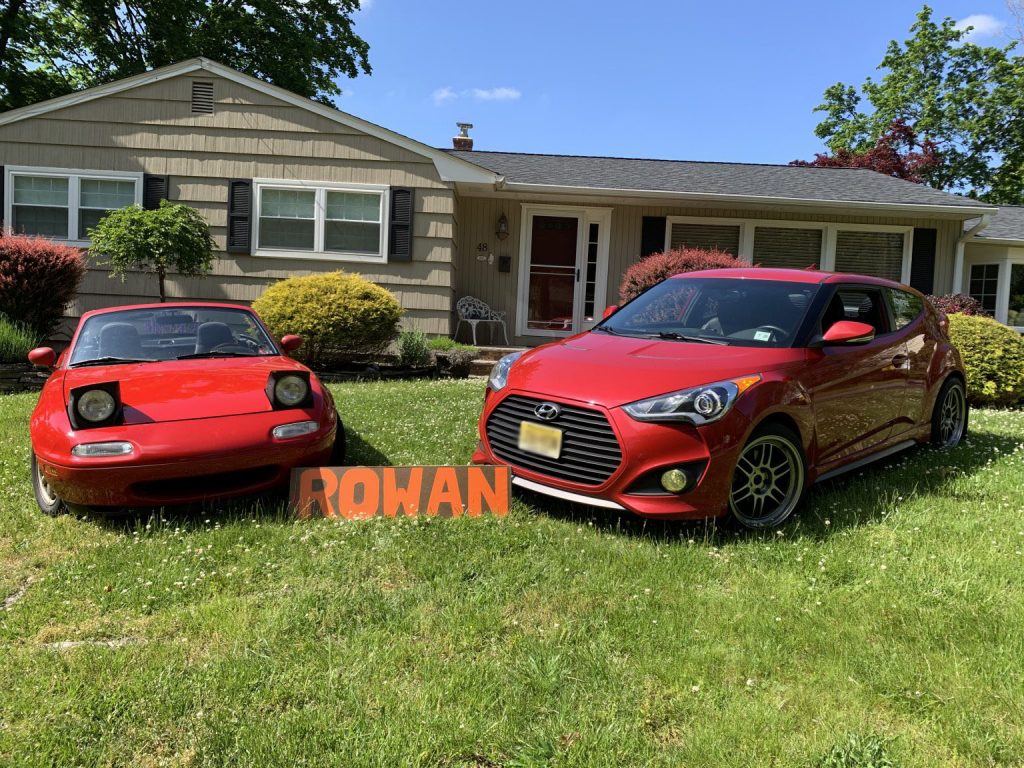 Photo of AJ Marchev's cars and Rowan sign outside his home. 