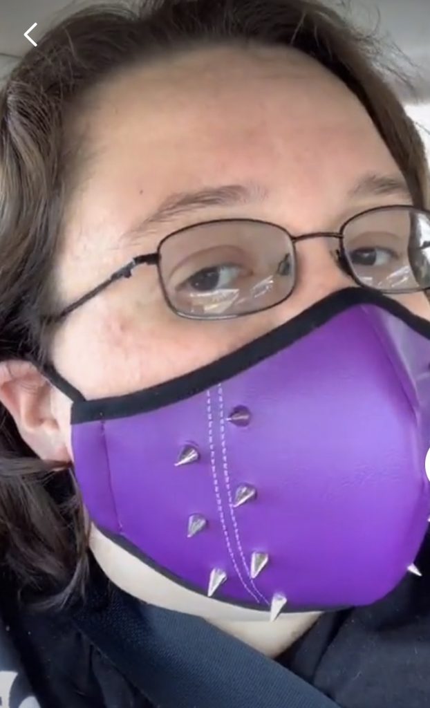 Psychology major Cellina Rodriguez wears a purple mask with spikes on the side. 