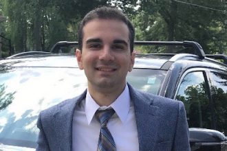 Alex pictured in professional attire.